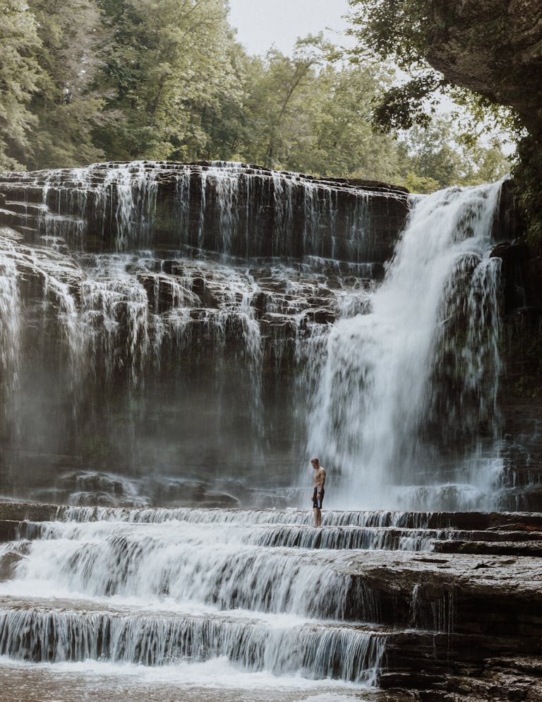 A stunning waterfall in Tennessee with a lone visitor experiencing its beauty.